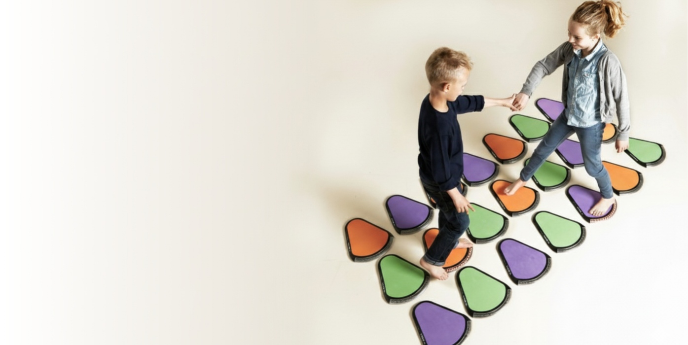 Dzieci ćwiczące na interaktywnych podkładkach Treax Pads podczas treningu motorycznego.