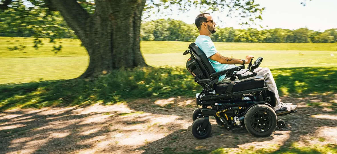 Osoba jadąca ścieżką na wózku inwalidzkim elektrycznym